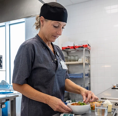 Køkkenmedarbejder anretter mad