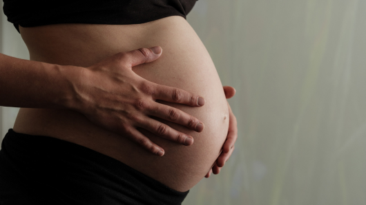 Gravid kvinde med siden til