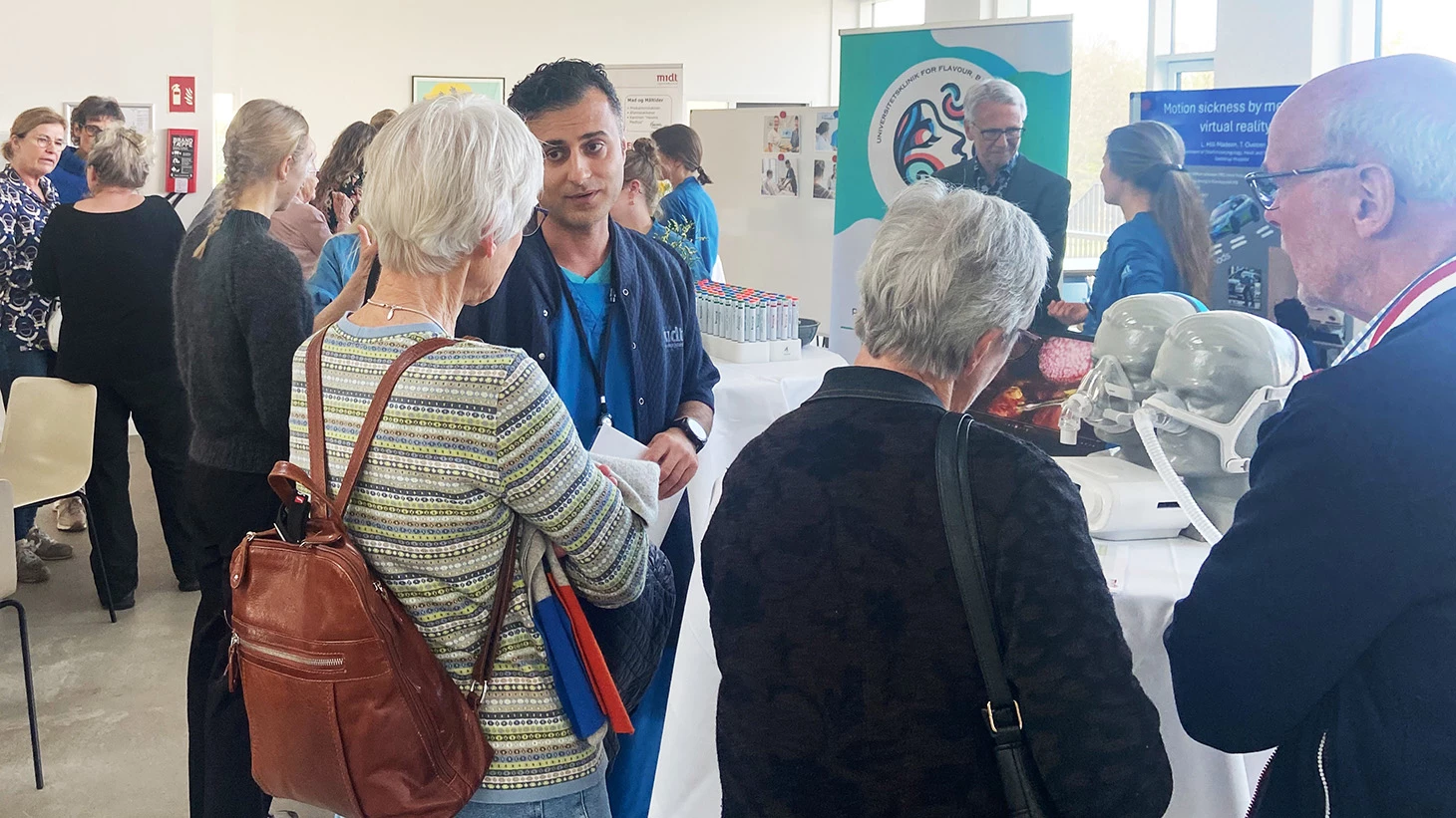 Personer der taler sammen og kigger på stande