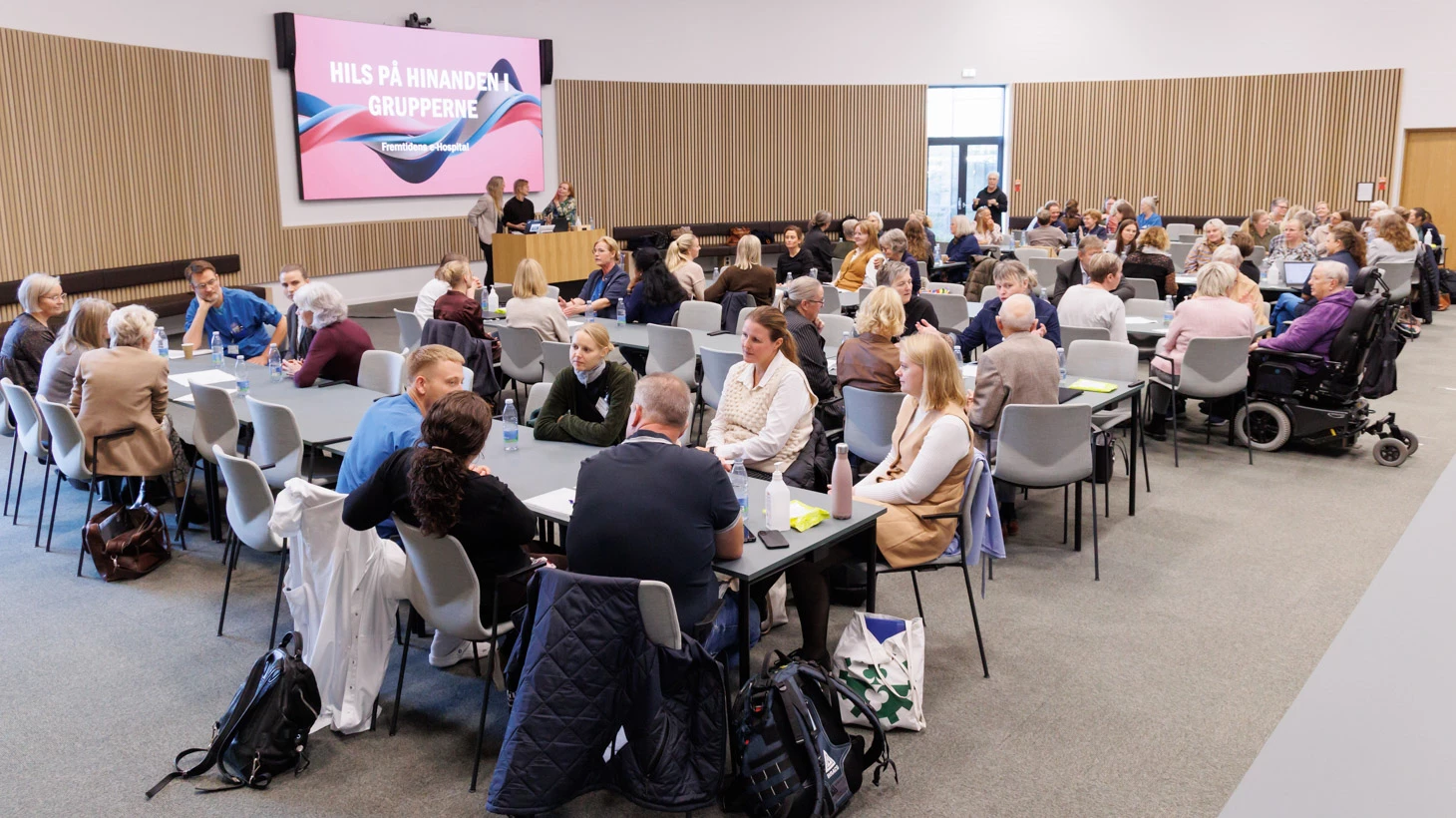 Gruppe af mennesker samlet i sal