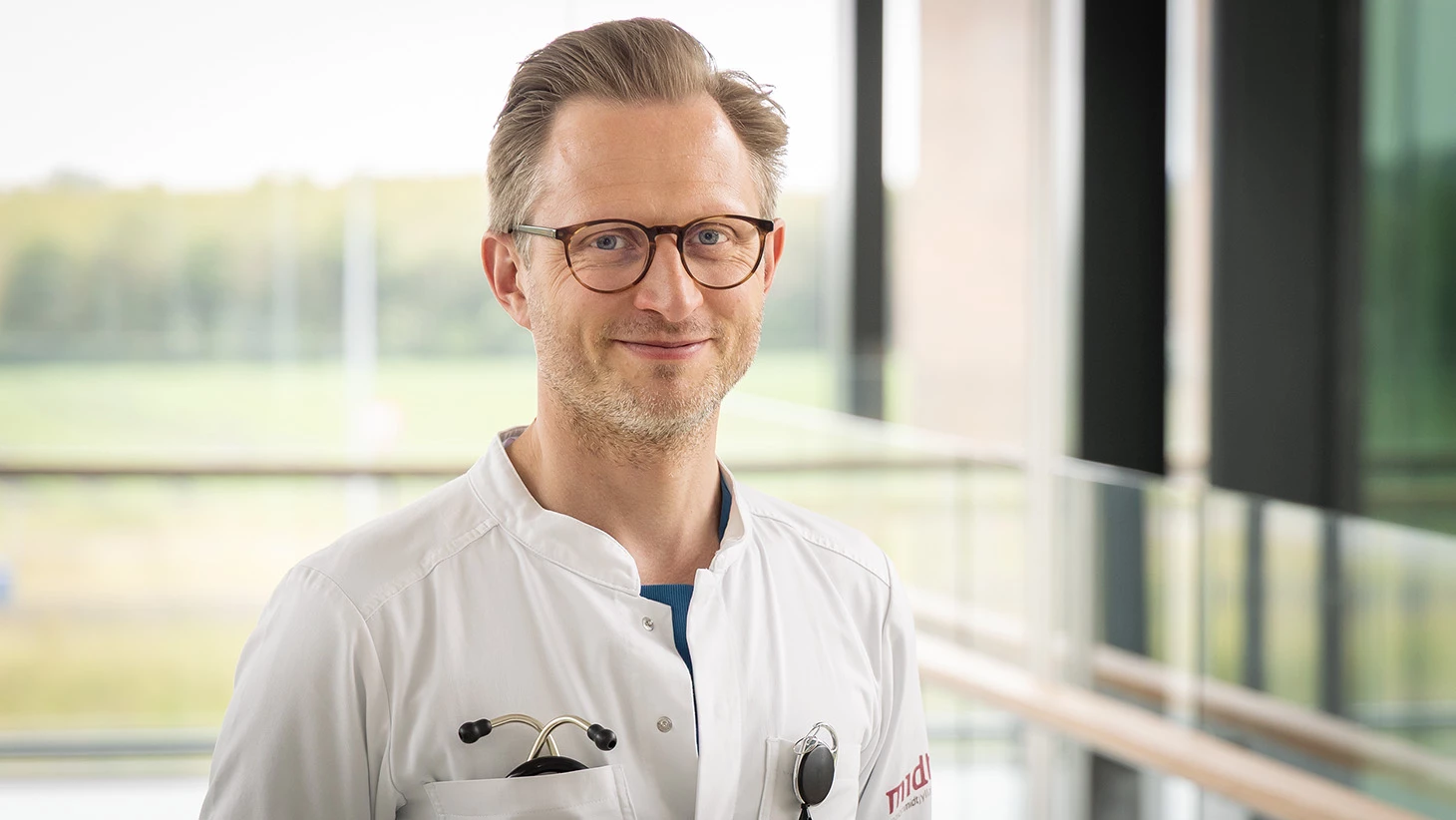 Portræt af mand med briller og i hvid lægekittel.