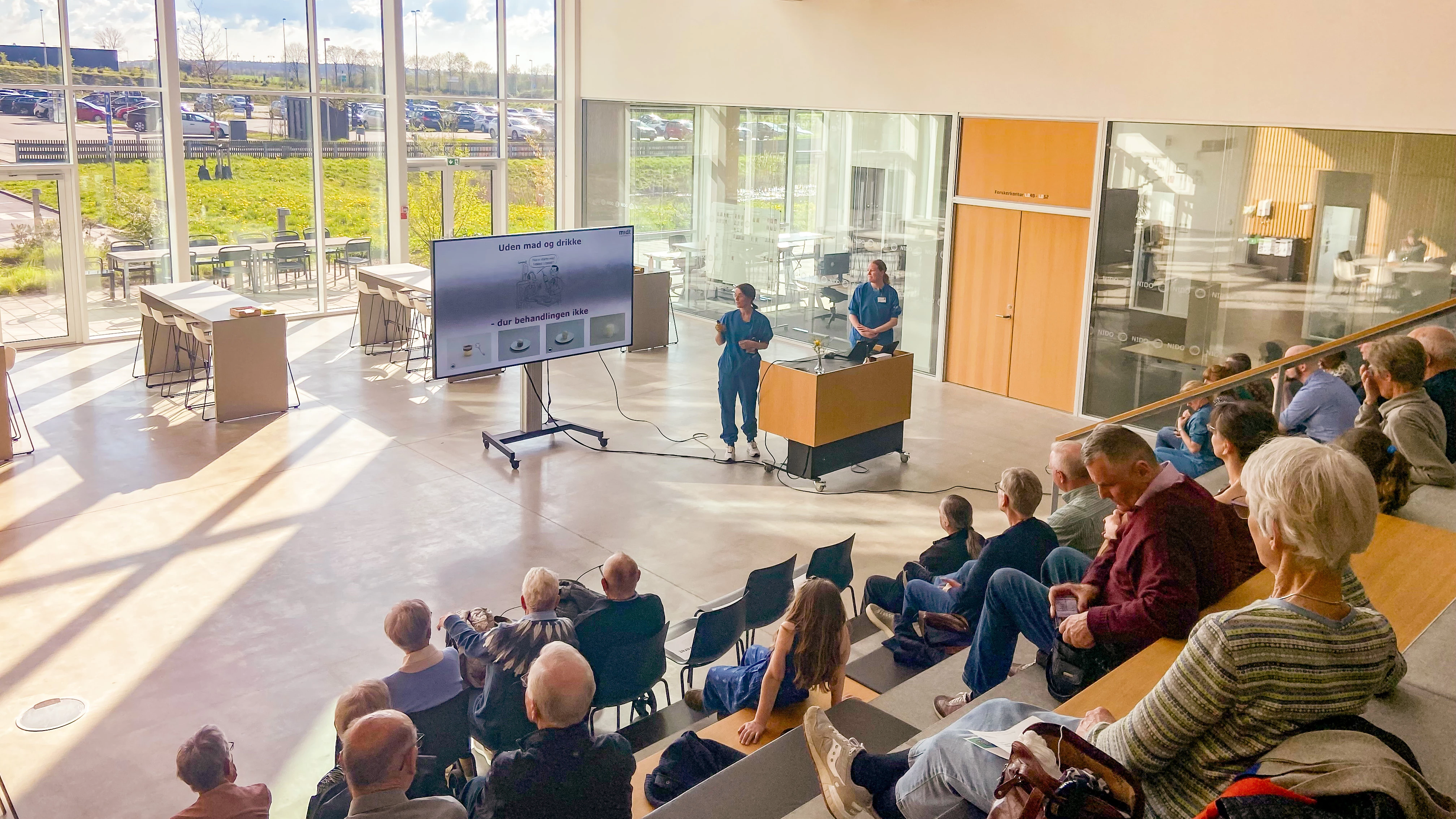 Forsamling af personer der lytter til et oplæg på hospitalet.