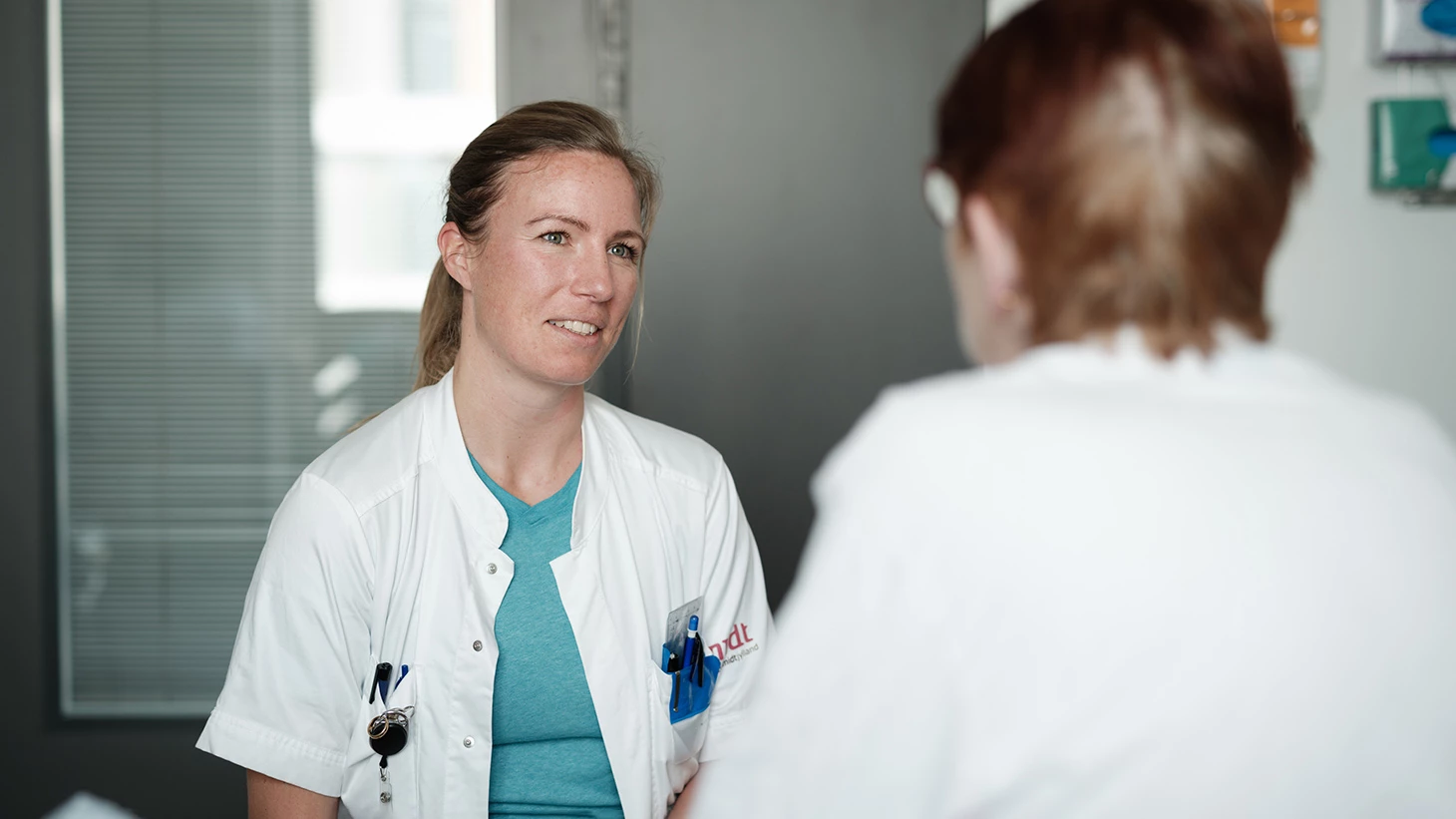 Sundhedsprofessionel taler med ældre patient