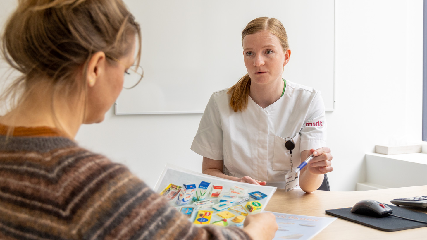 Patient og medarbejder sidder ved et bord og taler om ernæring