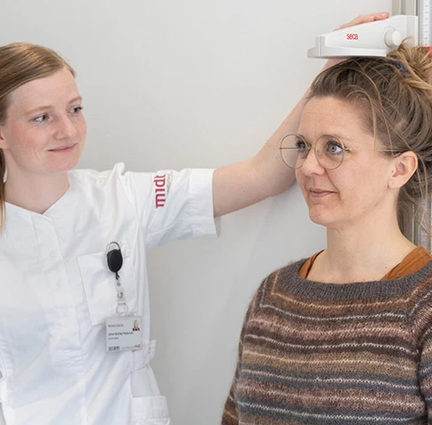 Sundhedsperson måler patients højde
