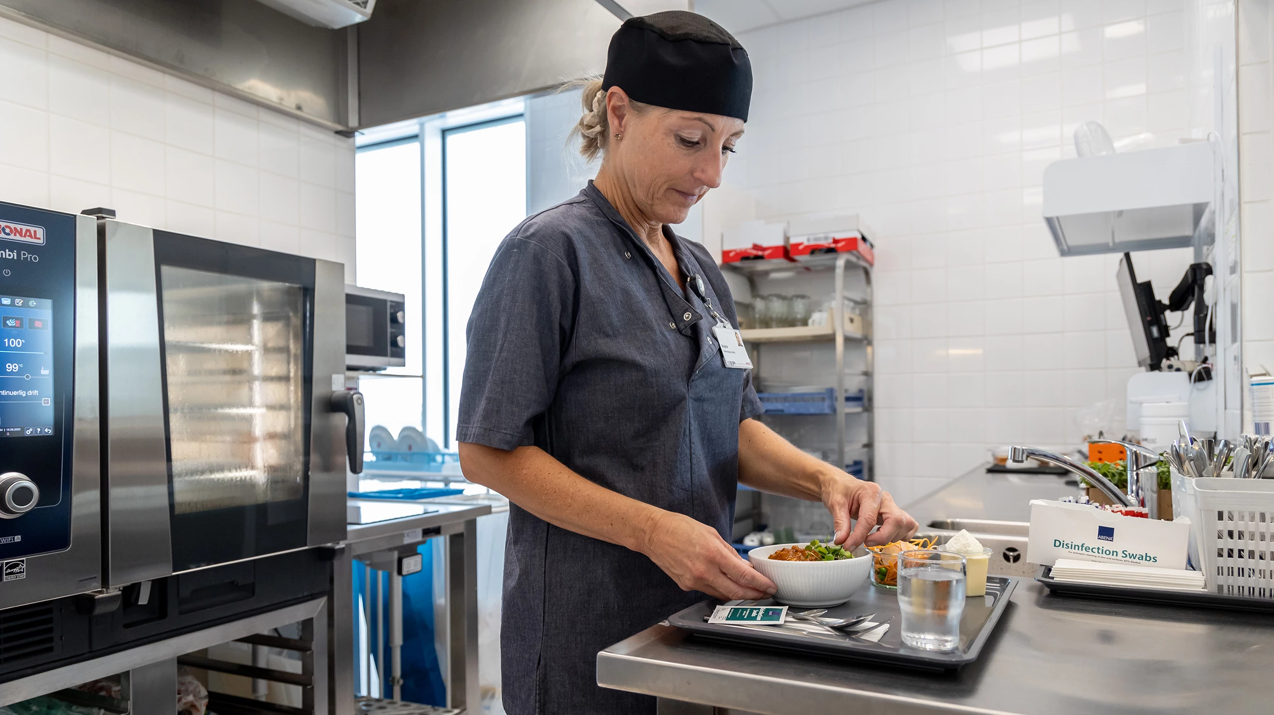 Køkkenmedarbejder anretter mad